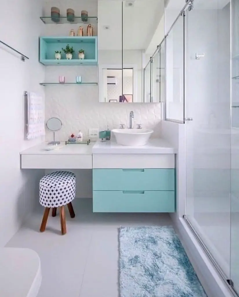 Banheiro pequeno com bancada de penteadeira em tons turquesa e branco 