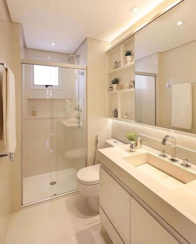 Banheiro pequeno em estilo clean com focos de luz e apliques em volta do espelho