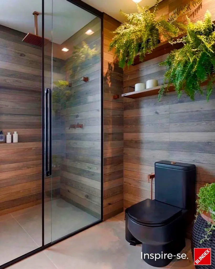 Banheiro pequeno moderno em tons escuros com box em vidro claro 