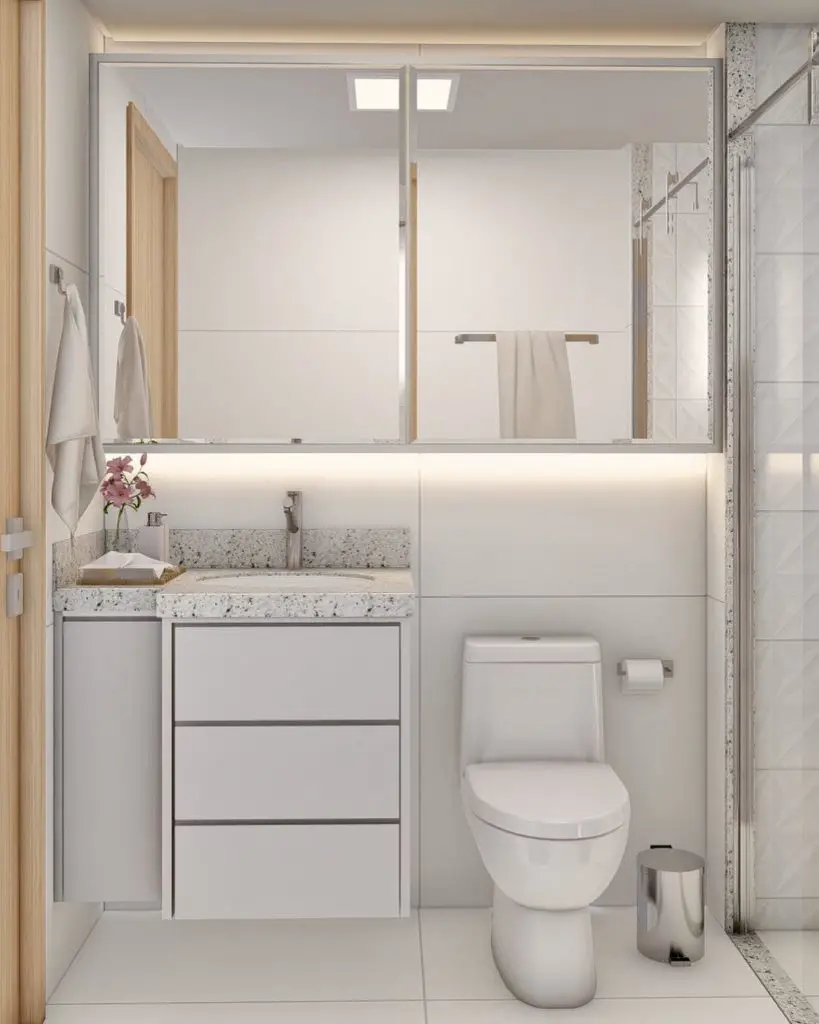 Banheiro pequeno com armário embaixo da pia e armário espelhado aproveitando o espaço em cima da pia e vaso sanitário 