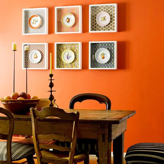 Espaço de refeição com parede pintada de laranja